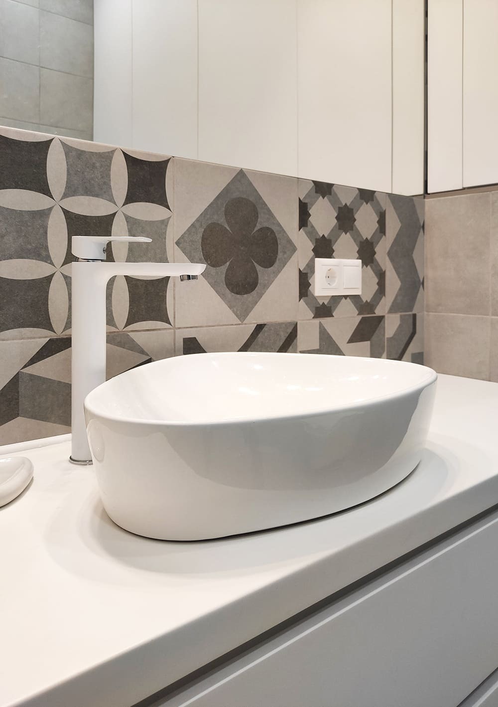 Белая накладная раковина на тумбе и серое плиточное панно с орнаментом