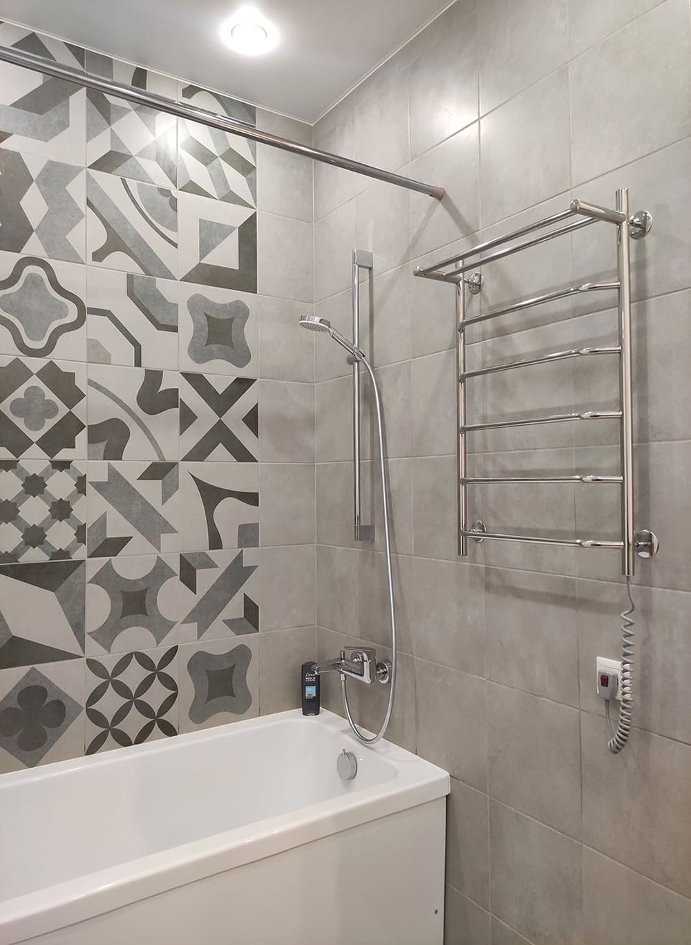 Белая накладная раковина и панно из серой геометрической плитки