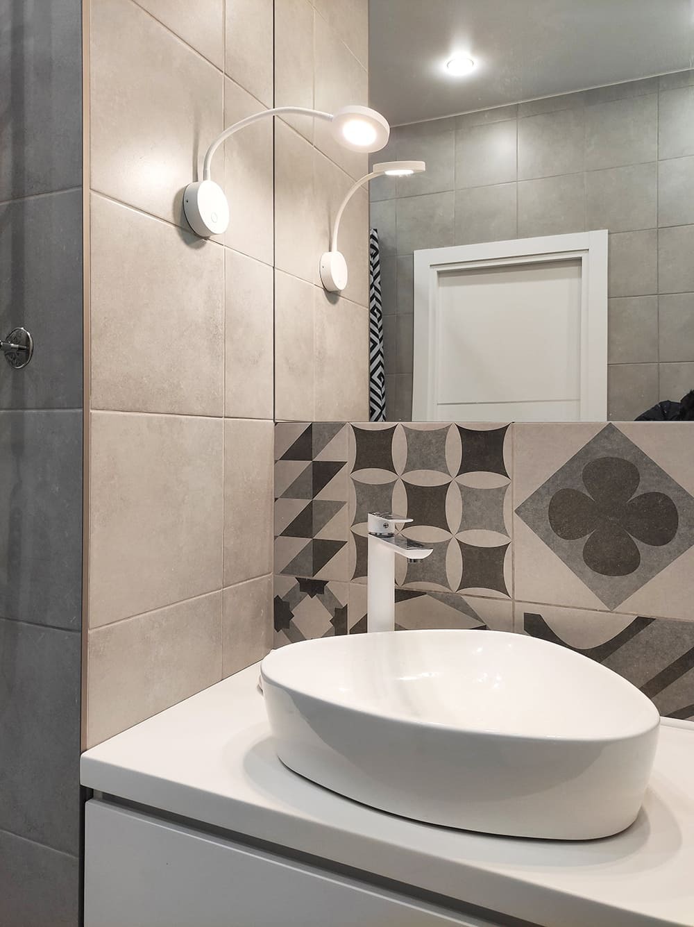 Современная раковина и плиточный фартук с геометрическим узором в санузле