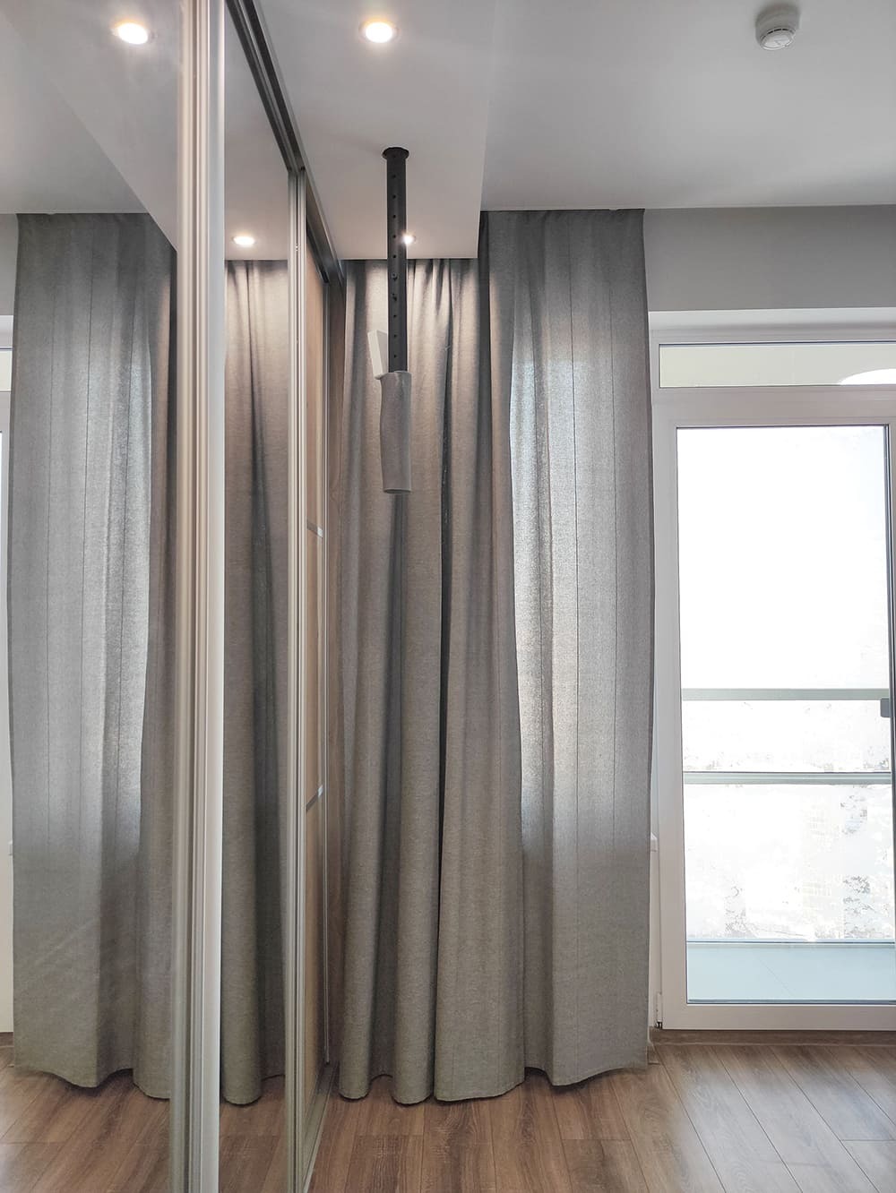 Реализованный дизайн спальни с зеркальным шкафом-купе и серыми шторами