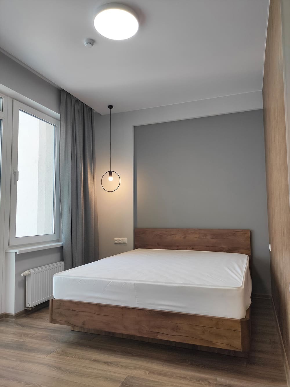 Современный дизайн спальни с деревянной кроватью и акцентной стеной