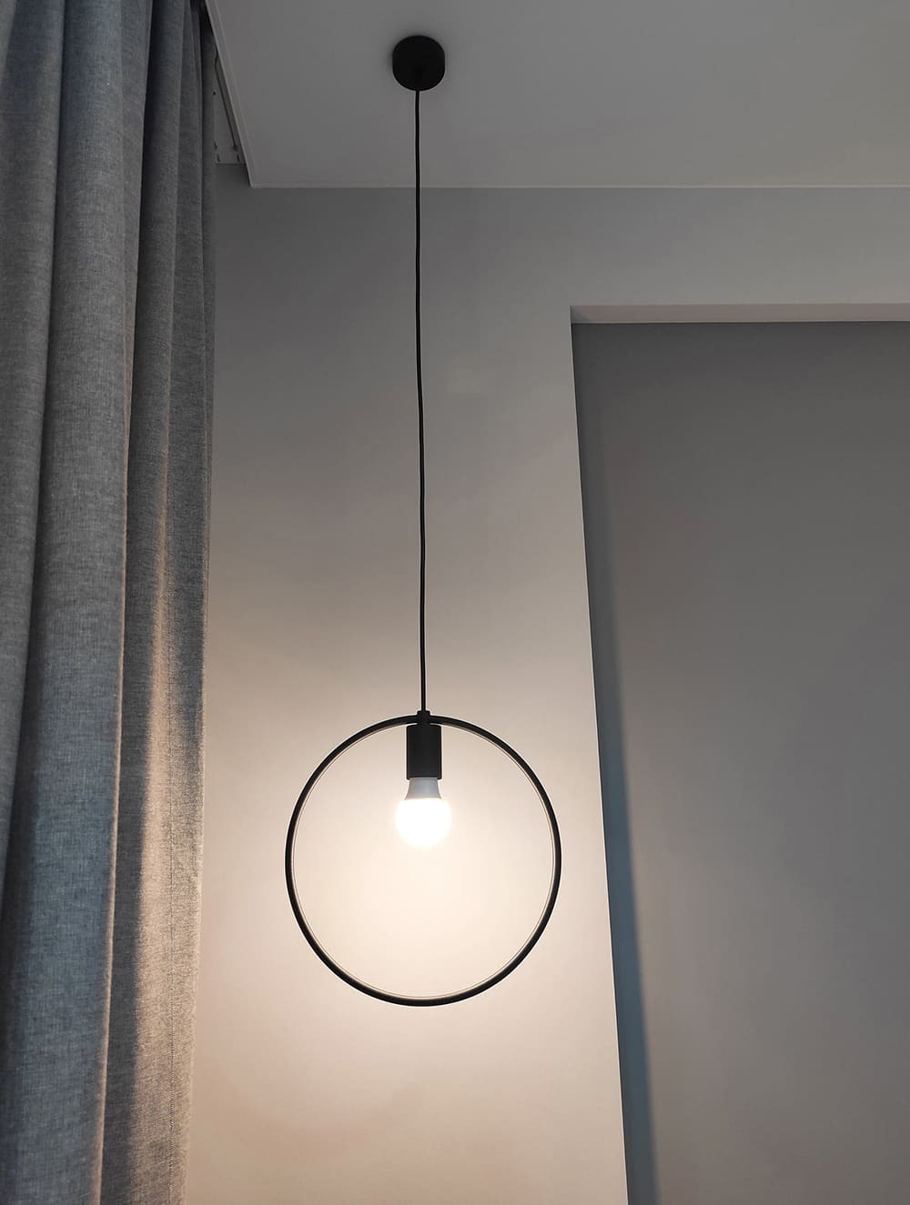 Деталь интерьера спальни &mdash; круглой подвесной светильник в зоне отдыха