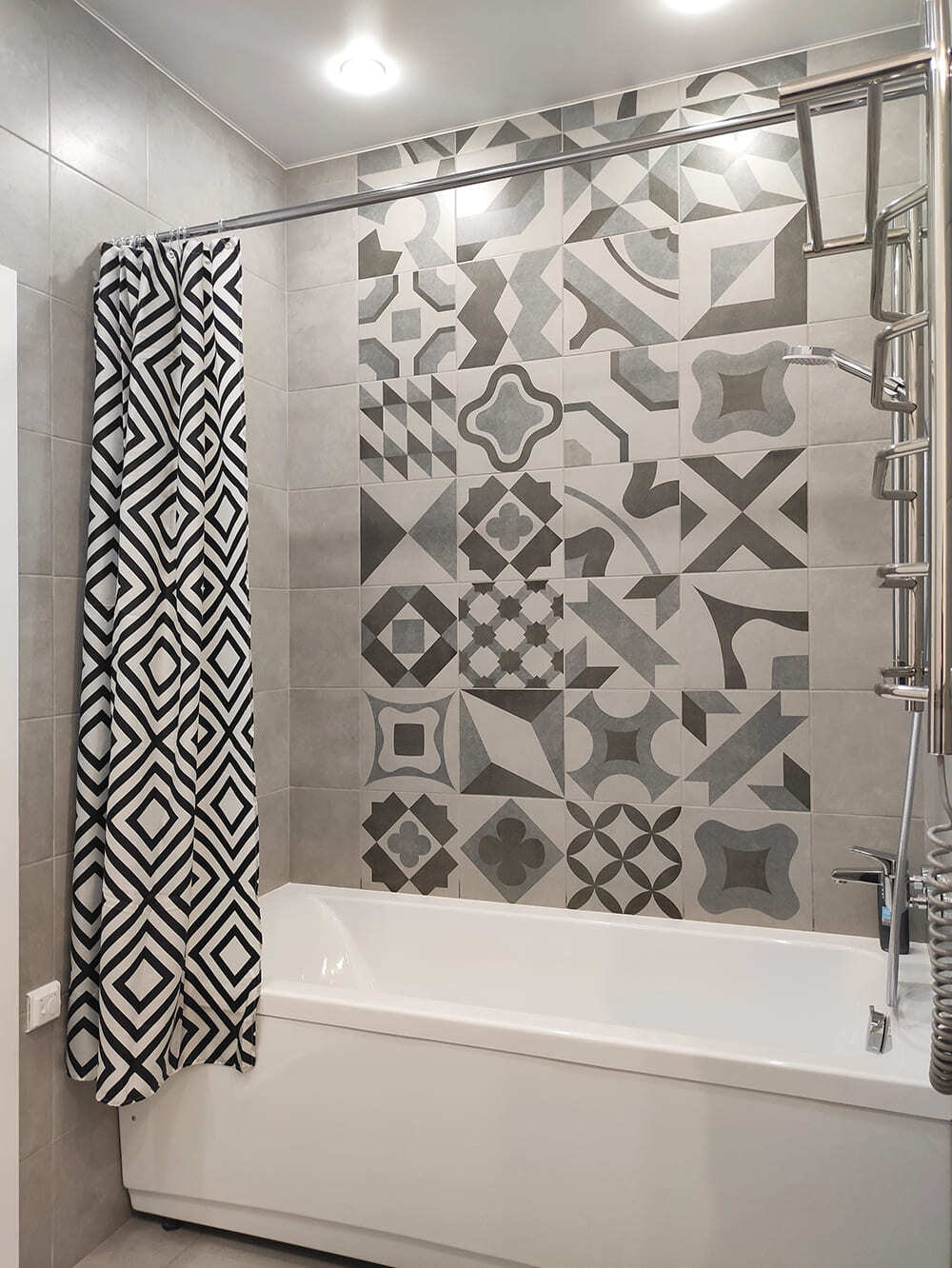 Ванная с декоративным панно из серой плитки с орнаментом и монохромной шторой