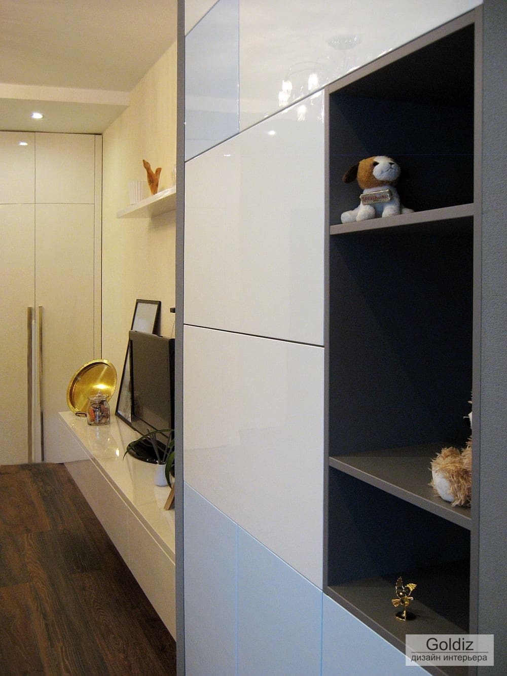 Гостиная с белым шкафом, закрытыми секциями, открытыми нишами и аккуратно оформленной ТВ-зоной