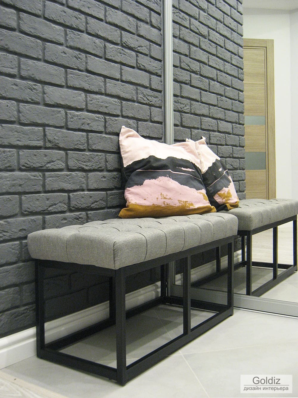 Интерьер прихожей с мягкой банкеткой, зеркалом во всю стену и комбинированными покрытиями пола