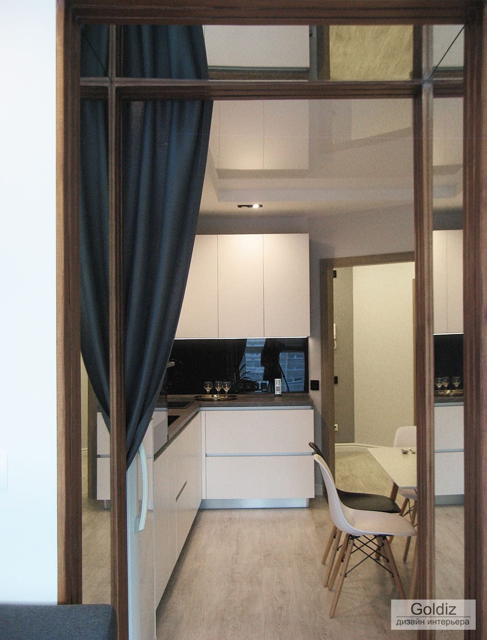 Вид кухни через декоративную деревянную перегородку с текстильным оформлением — зонирование пространства в современном интерьере