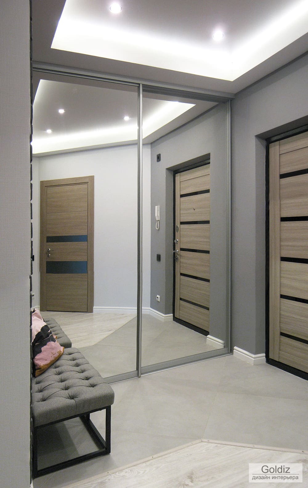 Прихожая с большим зеркальным шкафом-купе, потолочной подсветкой и дверьми в современном стиле