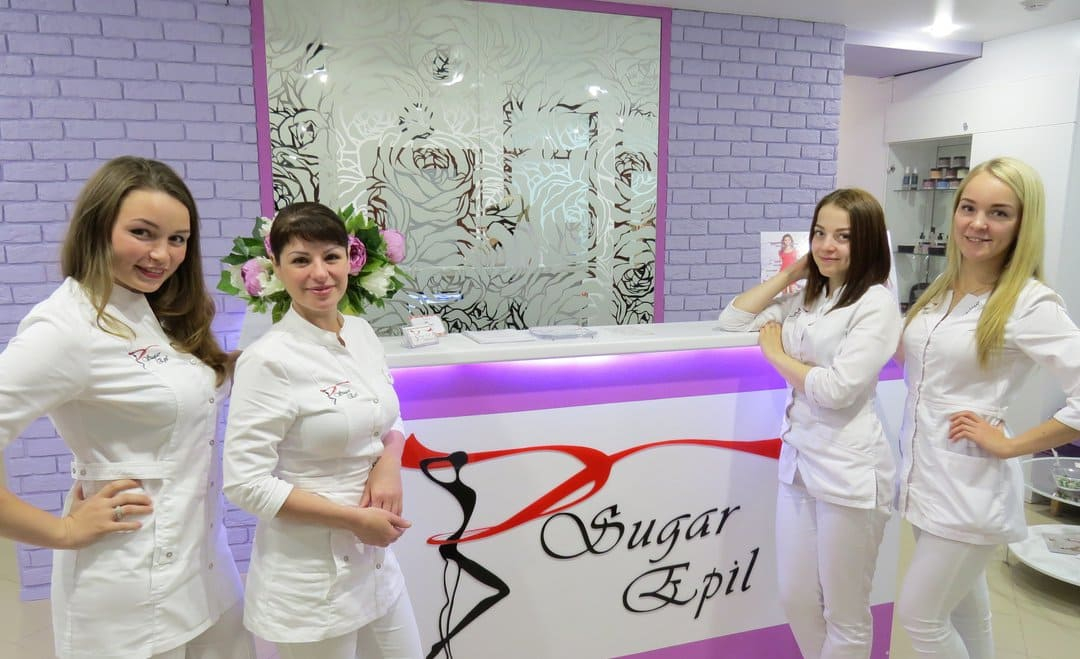 Коллектив профессионалов в белых униформах на фоне стильного ресепшн, который создает ощущение доверия и комфортной атмосферы.