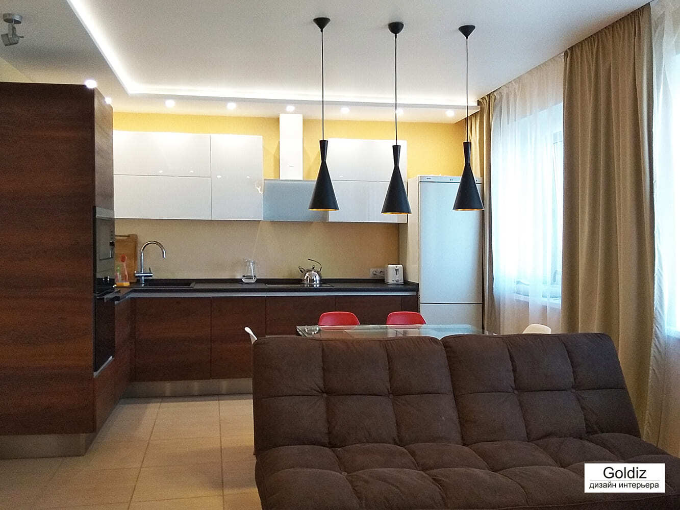 Современная кухня-гостиная с деревянными фасадами и подвесными светильниками